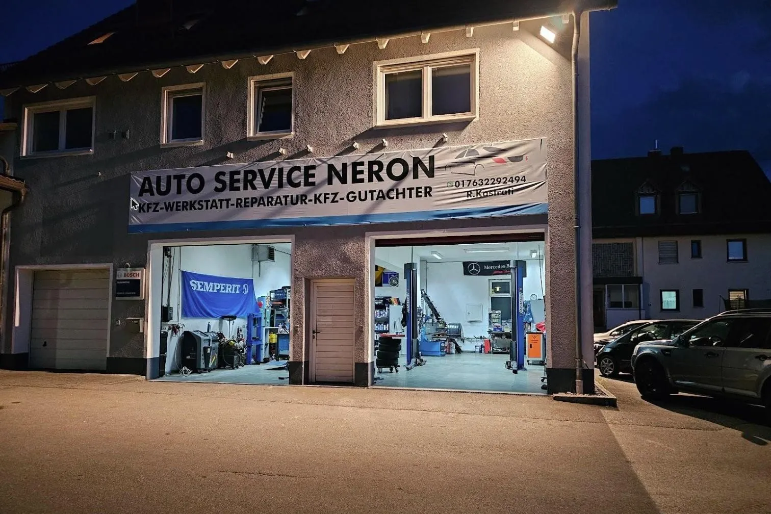 Auto Service Neron bei Nacht mit beleuchteter Halle